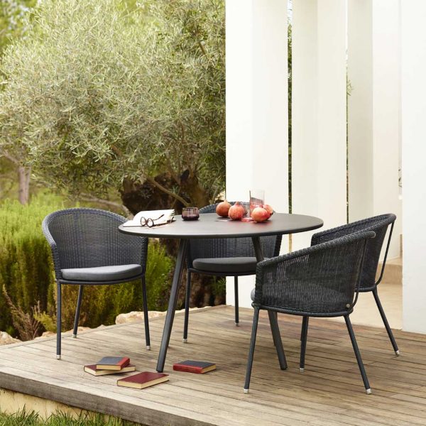 Image of Area round garden table and Trinity dining chairs by Caneline on wooden decking