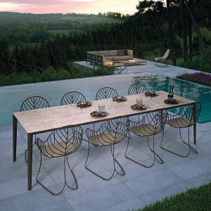Image at dusk of Unite marble garden table & Folia chairs by Royal Botania with rolling countryside in background