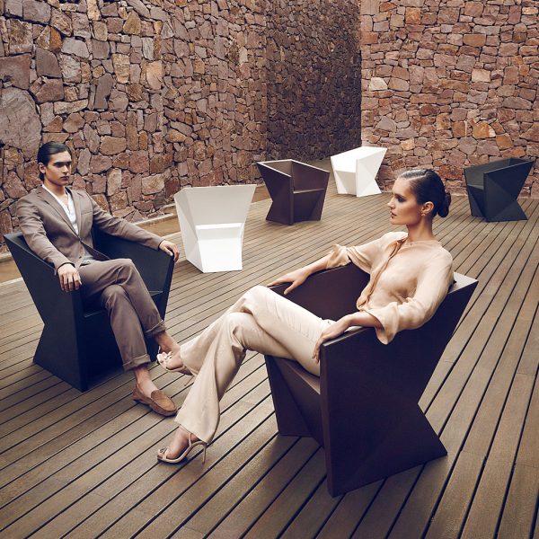 Image of man and woman sat in different coloured Faz modern garden dining chairs by Vondom, with other Faz chairs in the background