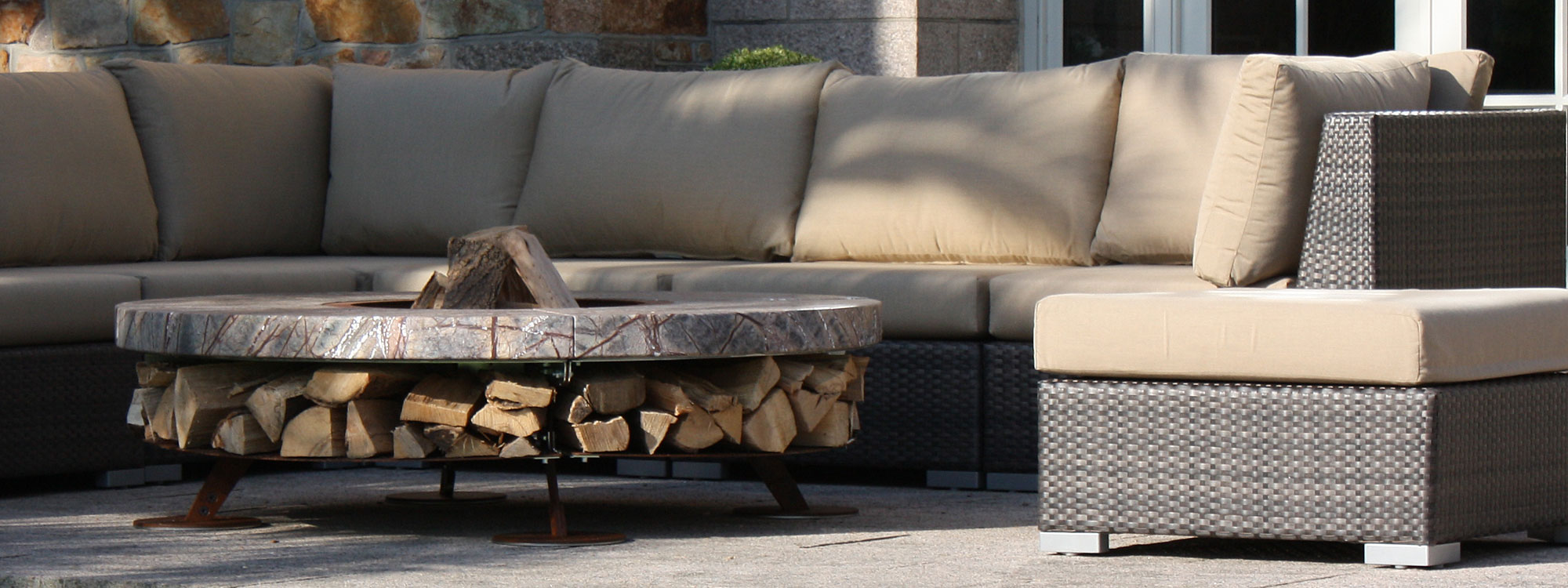 Image of AK47 Ercole luxury fire pit with marble surround, shown in the Channel Isles