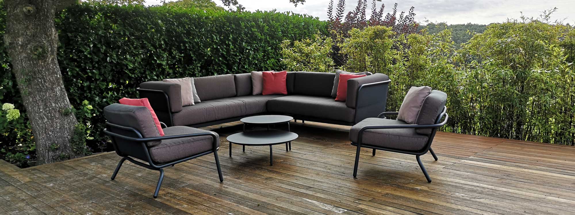 A photo of an L shaped garden sofa with luxury cushions and coffee tables
