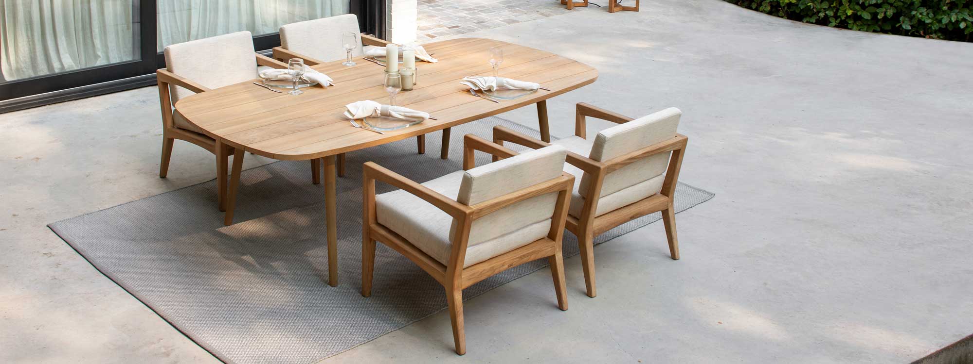 Zenhit low outdoor dining chair shown with Styletto low dining table is a versatile teak garden chair & comfy exterior lounge chair by Royal Botania modern teak furniture.