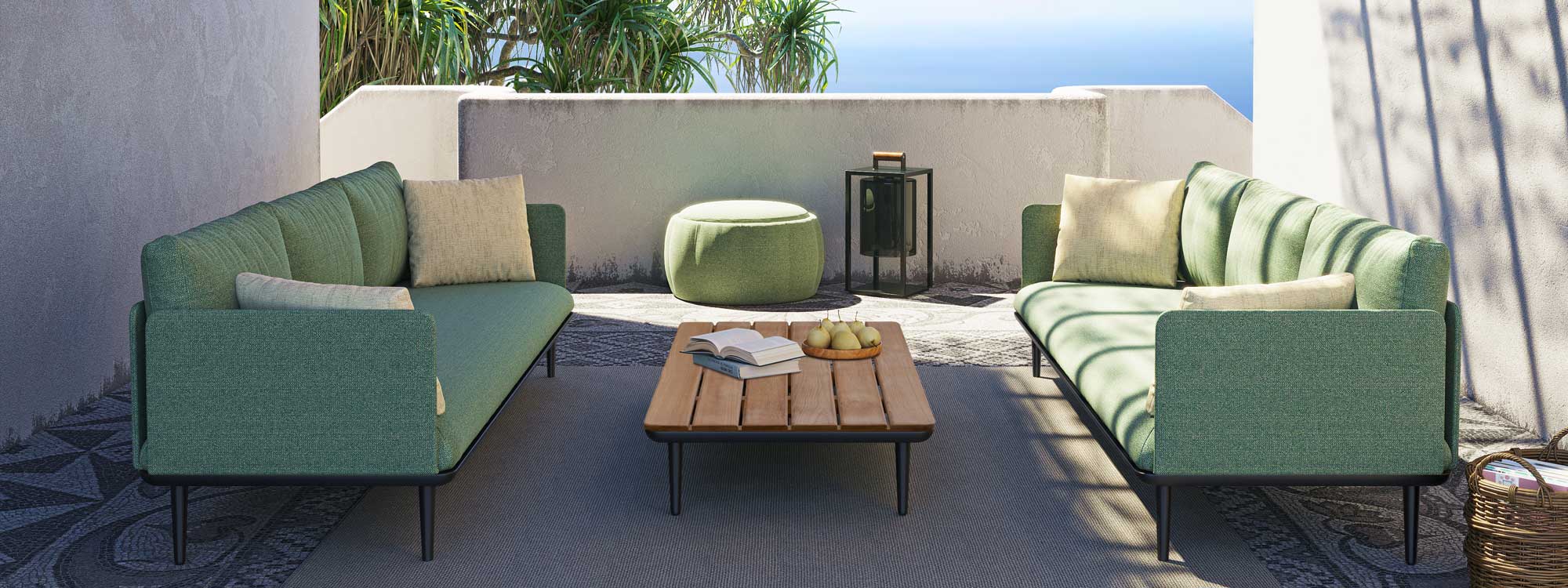 Styletto olive green garden sofas on carpeted outdoor terrace with azure sea in background