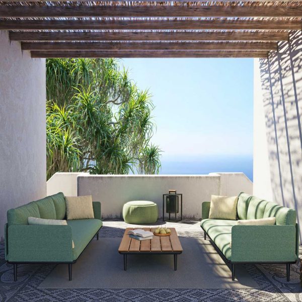 Styletto sofas and low table by Royal Botania beneath shaded pergola with azure sea in background