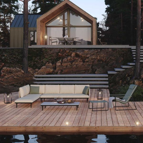 Royal Botania Strappy garden lounge chair & Styletto modern garden sofas on decking with minimalist house in background