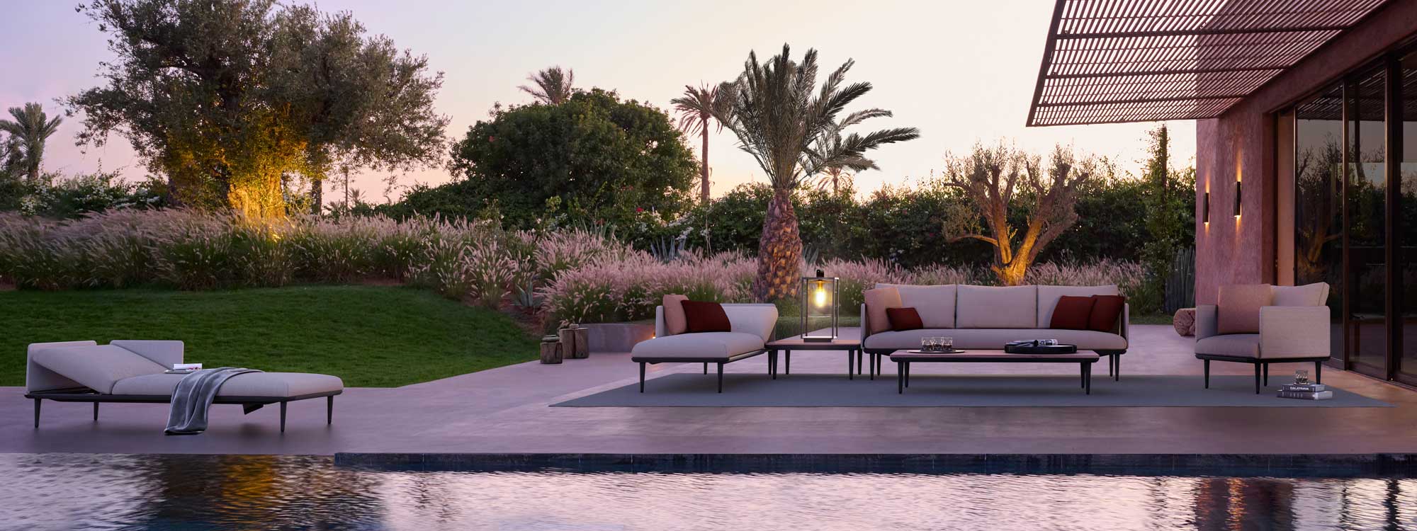 Sunset around poolside with Royal Botania Styletto modern garden sofa and Dome garden lamps