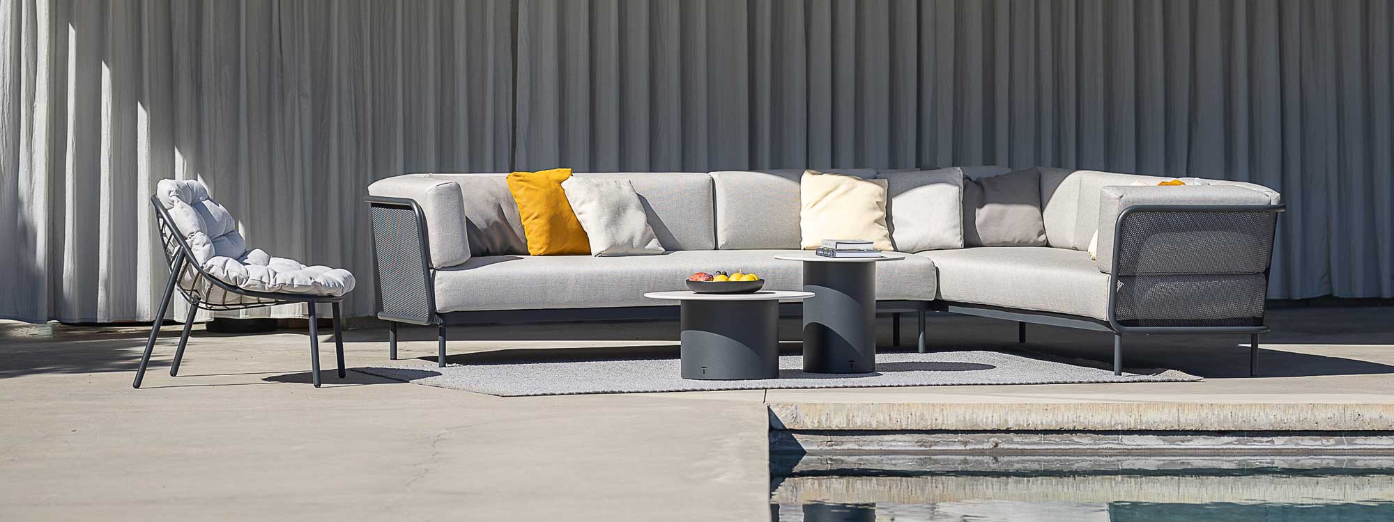 Image of Albus low backed garden relax chair and Baza modern garden corner sofa and Branta low tables, shown on sunny terrace