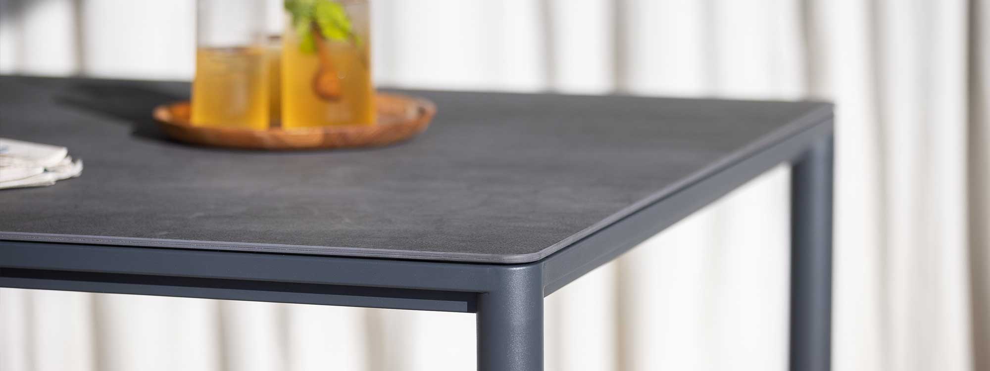 Image of detail of Alca garden table's slender frame and legs in powder coated stainless steel and ceramic table top