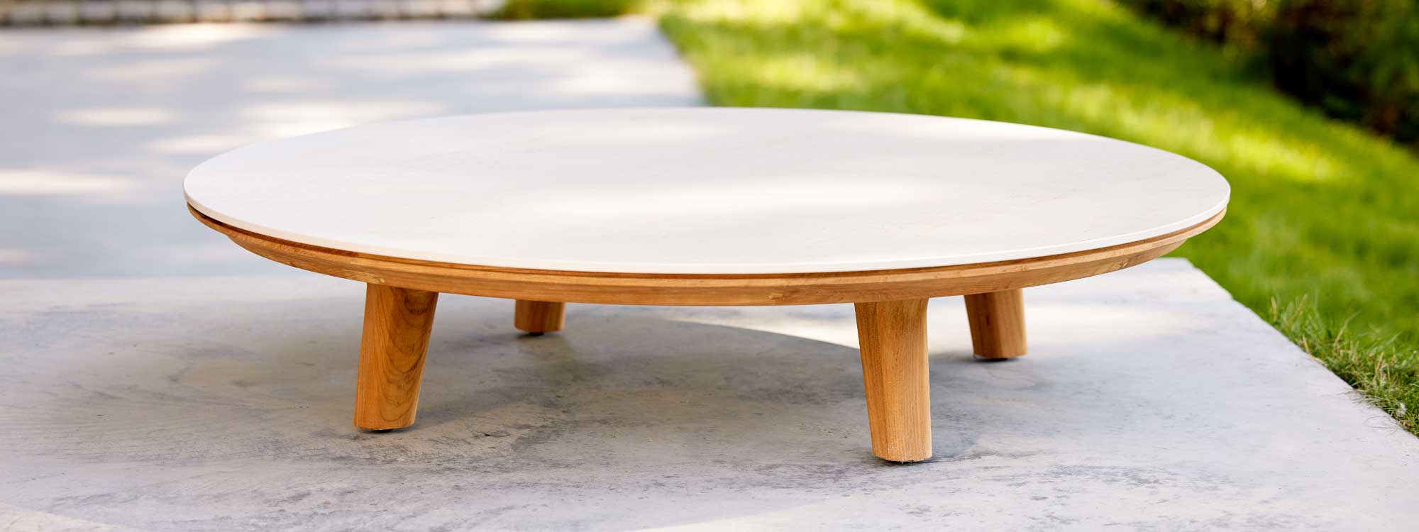 Image of Aspect large round coffee table with teak legs and Travertine ceramic top by Cane-line