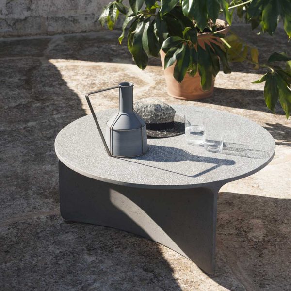 Image of RODA Aspic round concrete low table with water glasses, jug and hat on table top