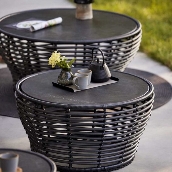 Image of pair of graphite colored Basket low tables with black fossil ceramic tops by Cane-line