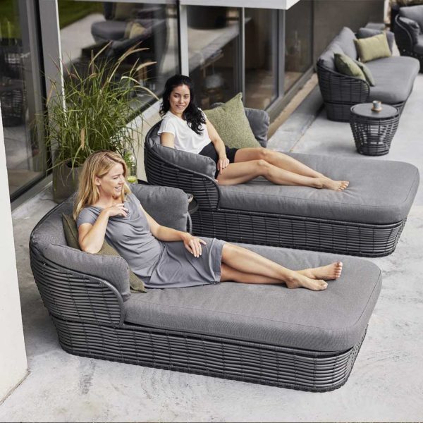Image of pair of women lying on Basket artificial cane daybeds by Caneline garden furniture