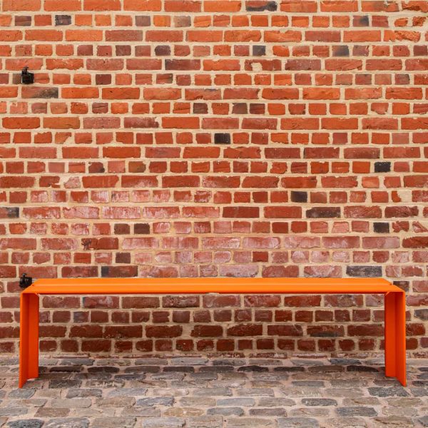 Image of The Bended orange garden furniture by Wünder, shown against brick wall