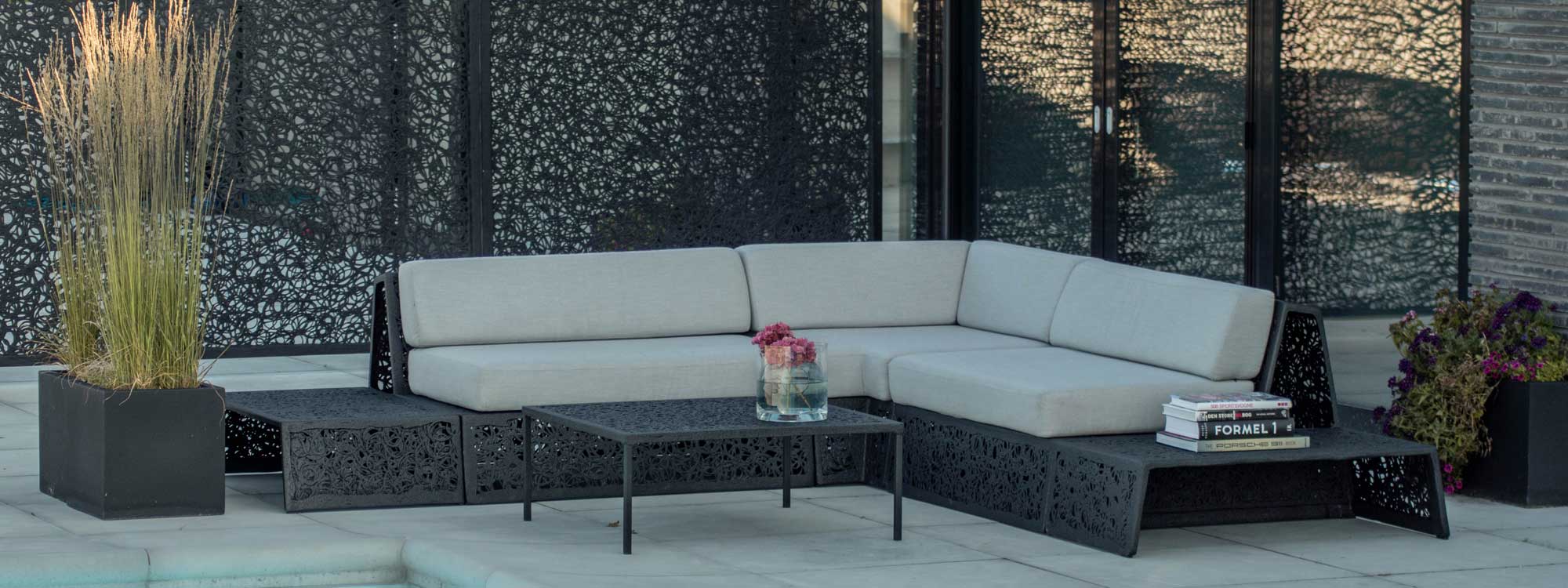 Image of Bios Lounge garden corner sofa in black, surrounded by lava fence panels by Unknown Nordic