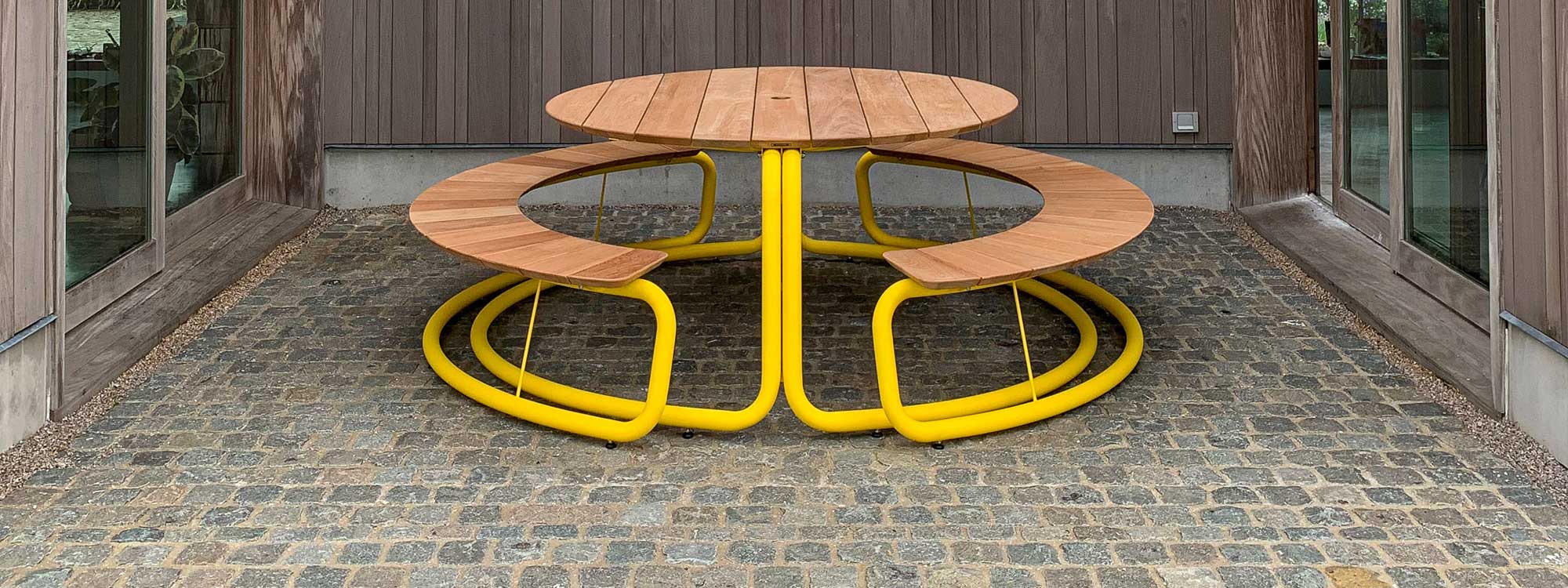 Image of The Circle circular picnic table and benches in yellow tubular steel with surfaces in sustainable afzelia wood by Wünder