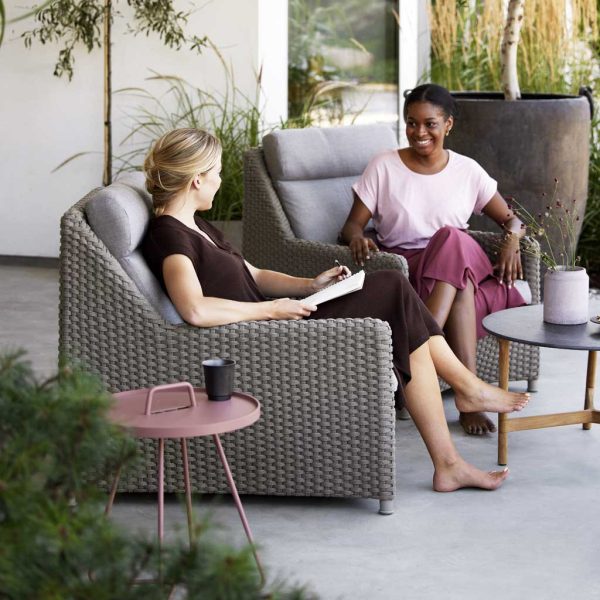 Image of women sat in Diamond high back lounge chairs in taupe Cane-line Soft Rope
