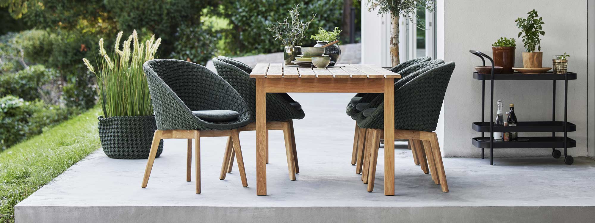 Image of Grace teak dining table and Peacock tub chairs on terrace by Cane-line garden furniture