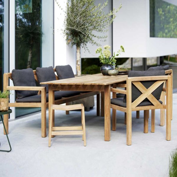 Image of Grace dining table, bench and chairs with dark grey cushions by Cane-line WWF teak furniture company