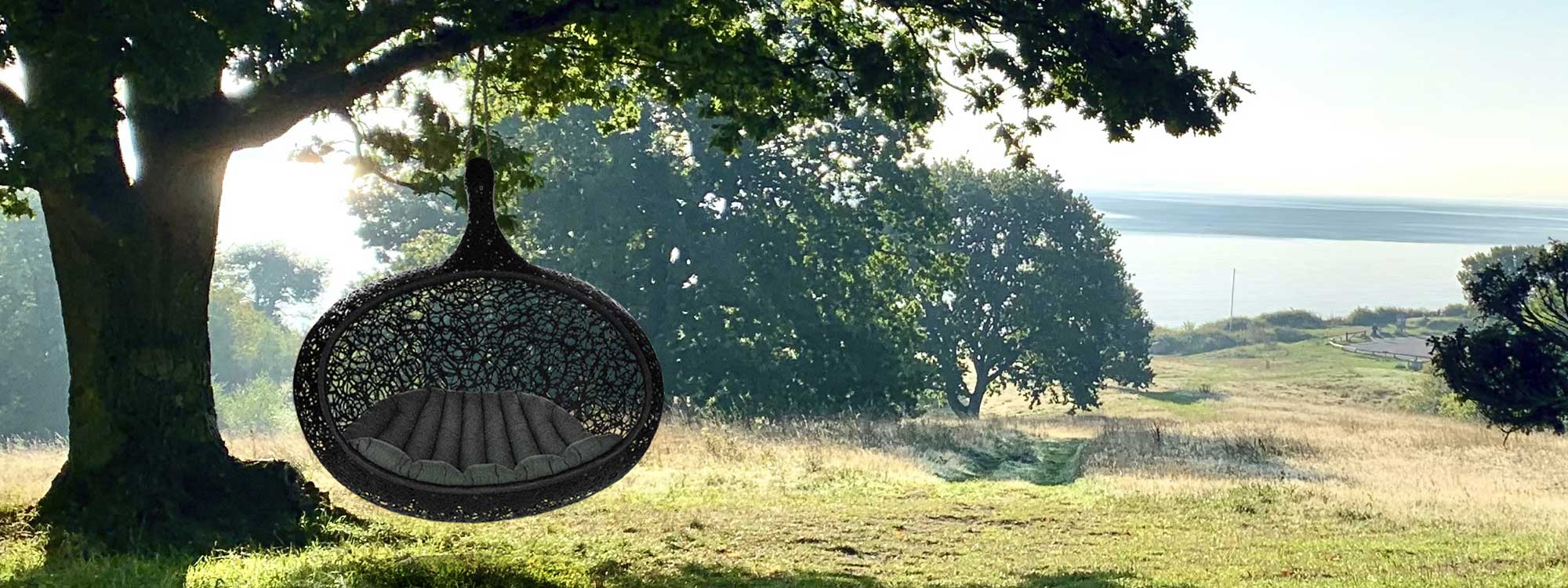 Image of Bios Hide garden swing seat with Danish countryside in background