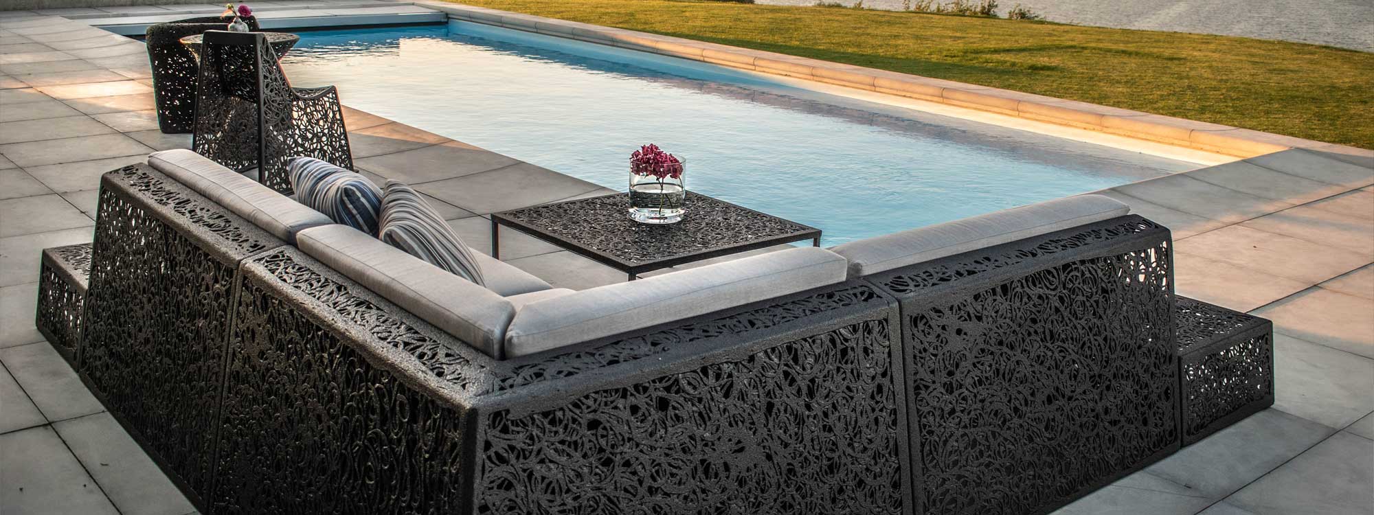 Image from back of Bios Lounge garden corner sofa by Unknown Nordic with swimming pool in background, showing the hand-made basalt fiber structure of the furniture