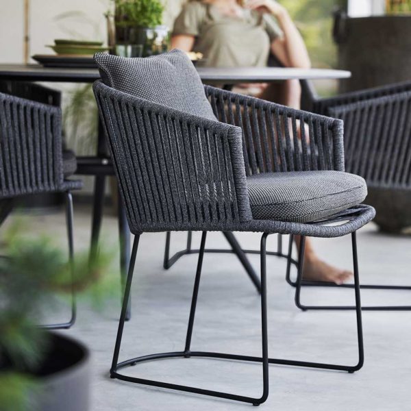 Image of dark grey Moments dining chair with sled legs with grey cushion by Caneline