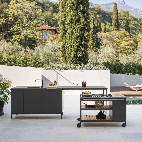 Image of Norma outdoor kitchen sink and gas BBQ by Roda, shown on terrace with cypress trees and villa on hill in background