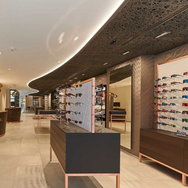 Image of high-end sunglasses shop featuring curvaceous black ceiling panels by Unknown Furniture