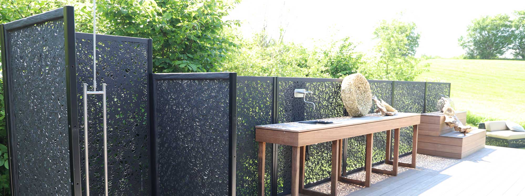 Image of Unknown Furniture Lava panels enclosing a garden shower next to a garden kitchen with lava panel wall behind it