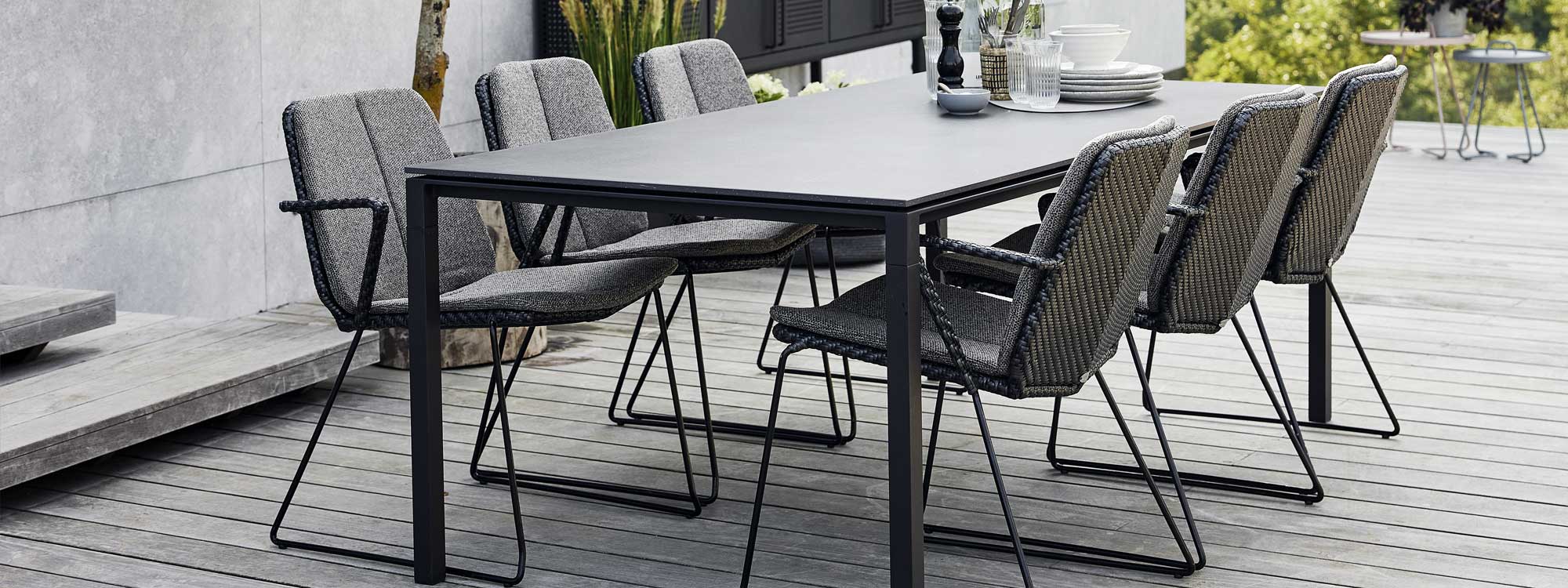Image of Vision black rattan garden chairs and Pure ceramic dining table by Cane-line