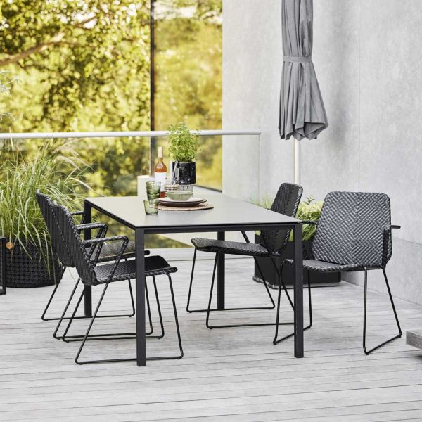 Image of Vision garden dining chairs and Pure dining table with lava-grey frame by Cane-line outdoor furniture