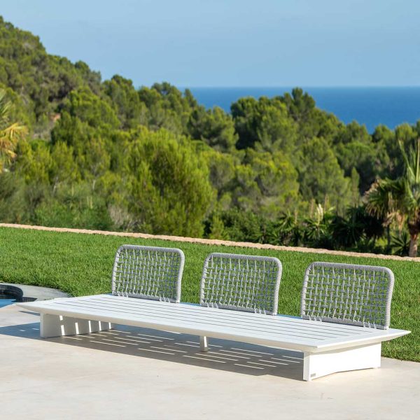 Image of Arbon garden sofa without arms, shown without cushions, with lawn, woodland and sea in the background