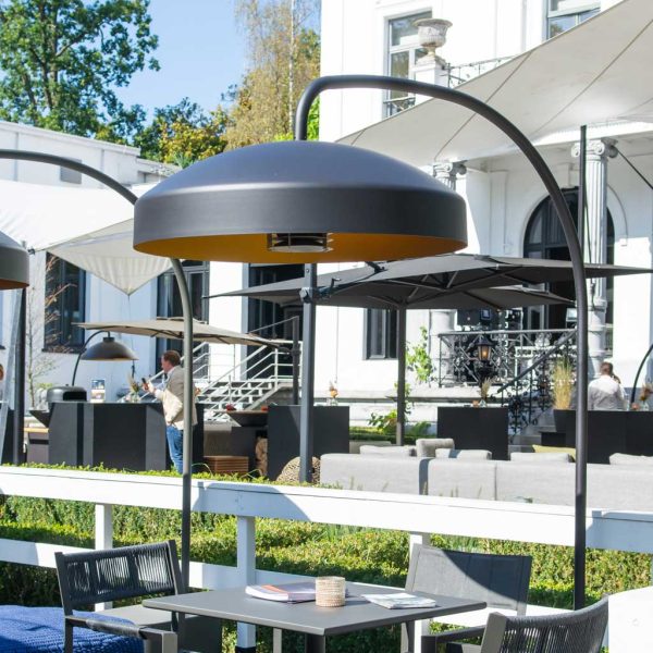 Image of mud-colored Disc heaters by Heatsail installed above furniture on restaurant's outdoor terrace