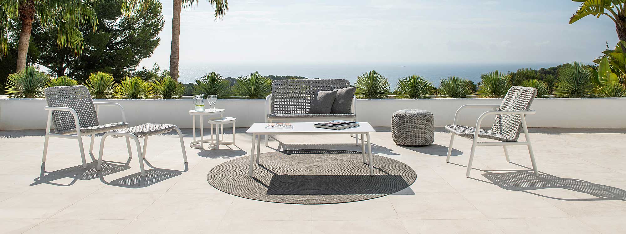 Image of Durham 2 seat garden sofa and lounge chairs with white tubular aluminium frame and white-grey Polyolefin hand-woven rope seat & back on sunny terrace