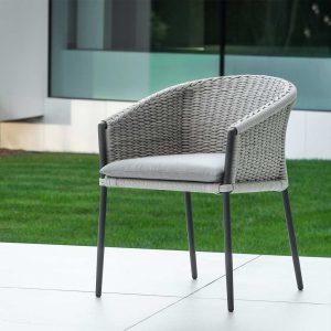 Image of Fortuna Rope garden tub chair with charcoal black frame and Beige-uni rope back, shown on sleek terrace with lawn and floor to ceiling windows in the background