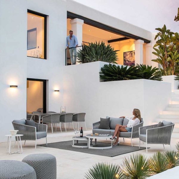 Image of white Fortuna Rope contemporary garden furniture with grey melange woven rope backs, shown in white-washed terrace at dusk