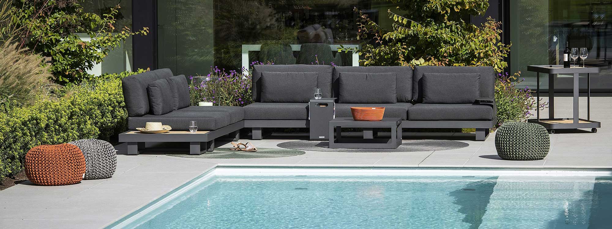 Image of Fano dark grey garden sofa with dark grey cushions on sunny poolside