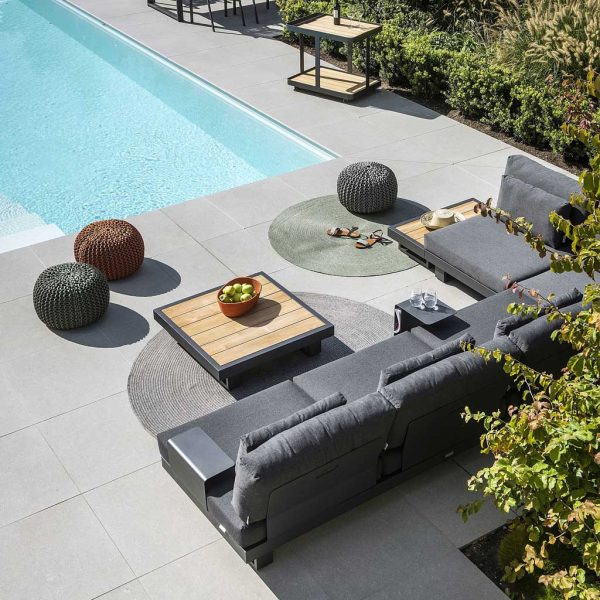 Image of Fano dark grey garden corner sofa with teak topped low table, on sunny poolside