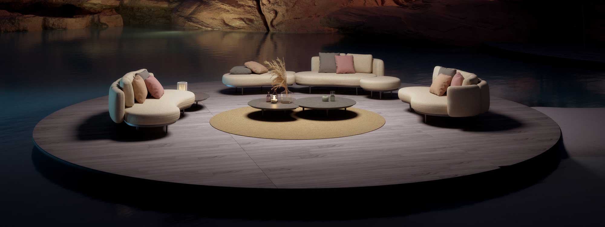 Nighttime image of Royal Botania Organix lounge furniture on illuminated circular platform surrounded by water
