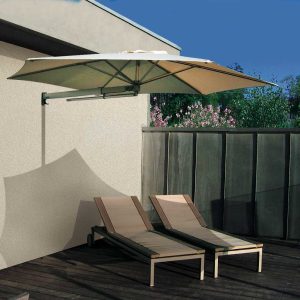 Image of Prostor P3 wall mounted parasol with cream canopy and anodised aluminium arm, shown above a pair of sun loungers
