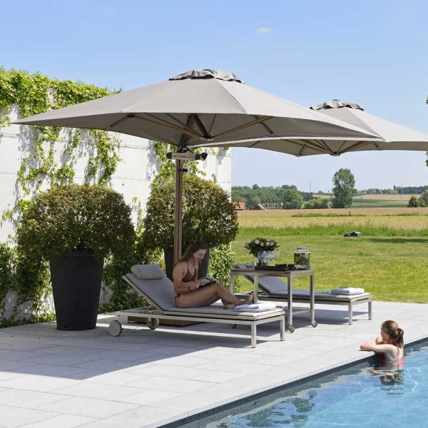 Image of Prostor P6 twin cantilever parasol with taupe canopies shown on sunny poolside