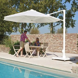 Image of Prostor P7 white octagonal cantilever parasol on poolside above teak dining furniture