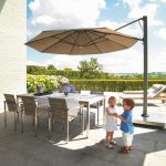 Image of Prostor P7 side post parasol with taupe canopy, with 2 children playing beneath the canopy