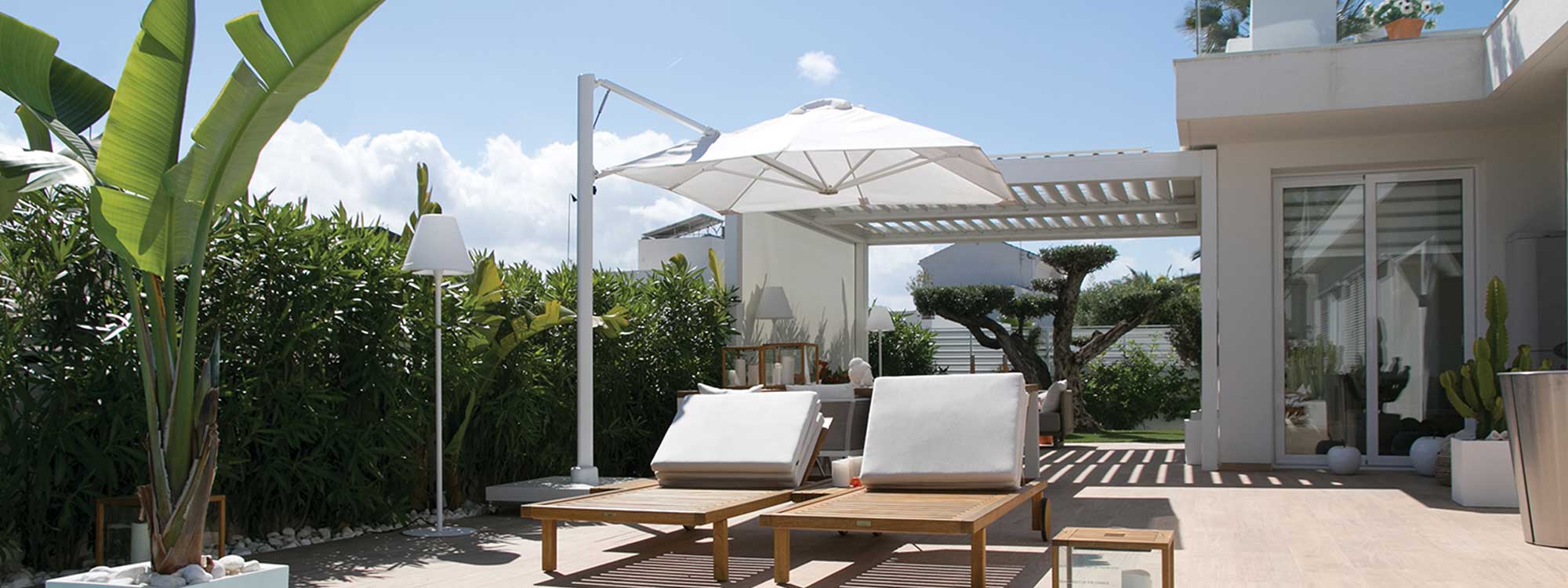 Image of Prostor P7 square white garden parasol in trendy white-washed back garden with tropical plants and 2 teak sunbeds