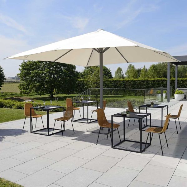 Image of Prostor 8 large white parasol above 4 bistro sets on a sunny terrace
