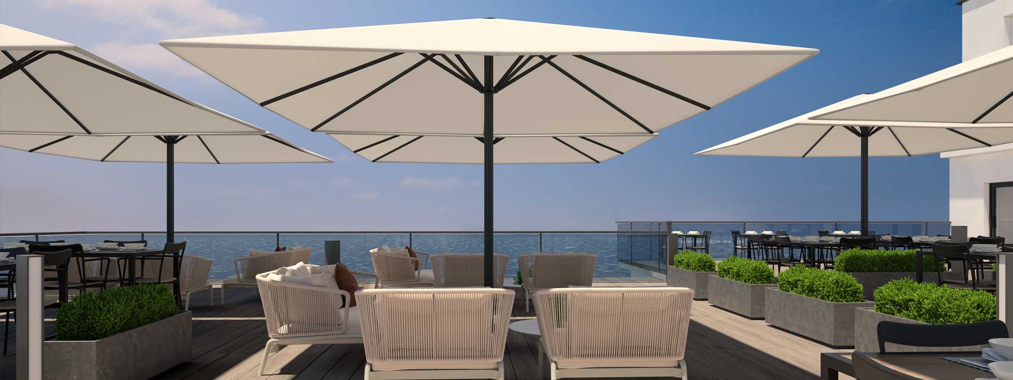 Image of Prostor P8 large mast parasols above outdoor furniture in beachside cafe and restaurant
