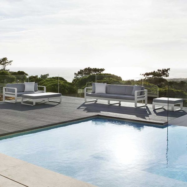 Image looking across pool with Reno modern garden lounge furniture on wooden decking on the other side