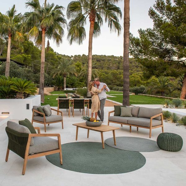 Image of couple dancing on terrace in amongst Jati & Kebon garden furniture, with exotic planting and lawns in the background