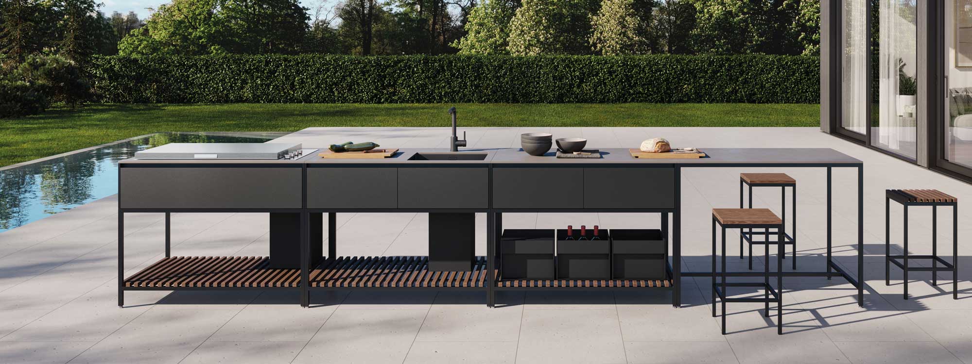 Image of Conmoto Ticin Frame modern garden kitchen island, shown on terrace next to linear water feature, with lawn and hedge in the background