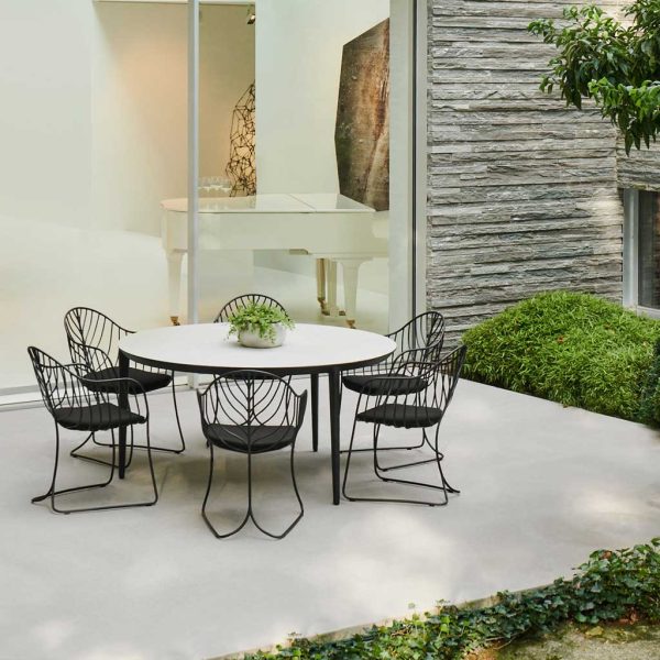 Image of Folia minimalist garden chairs around a circular U-nite ceramic garden table