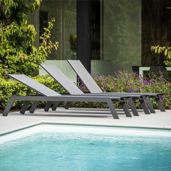 Image of row of 3 Vigo XL sun loungers with back rests adjusted into different positions, shown in sunny poolside